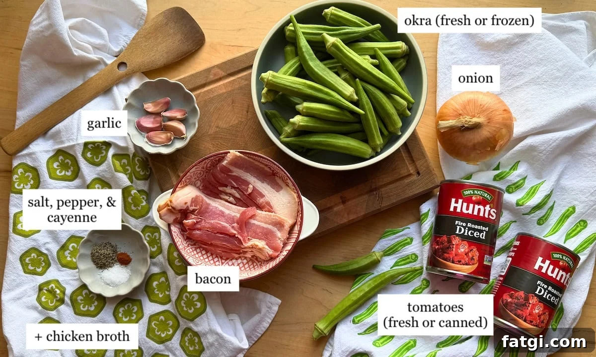 A wooden spoon, garlic, bacon, spices, chicken broth, and fresh or canned tomatoes arranged on a countertop with okra and onion.