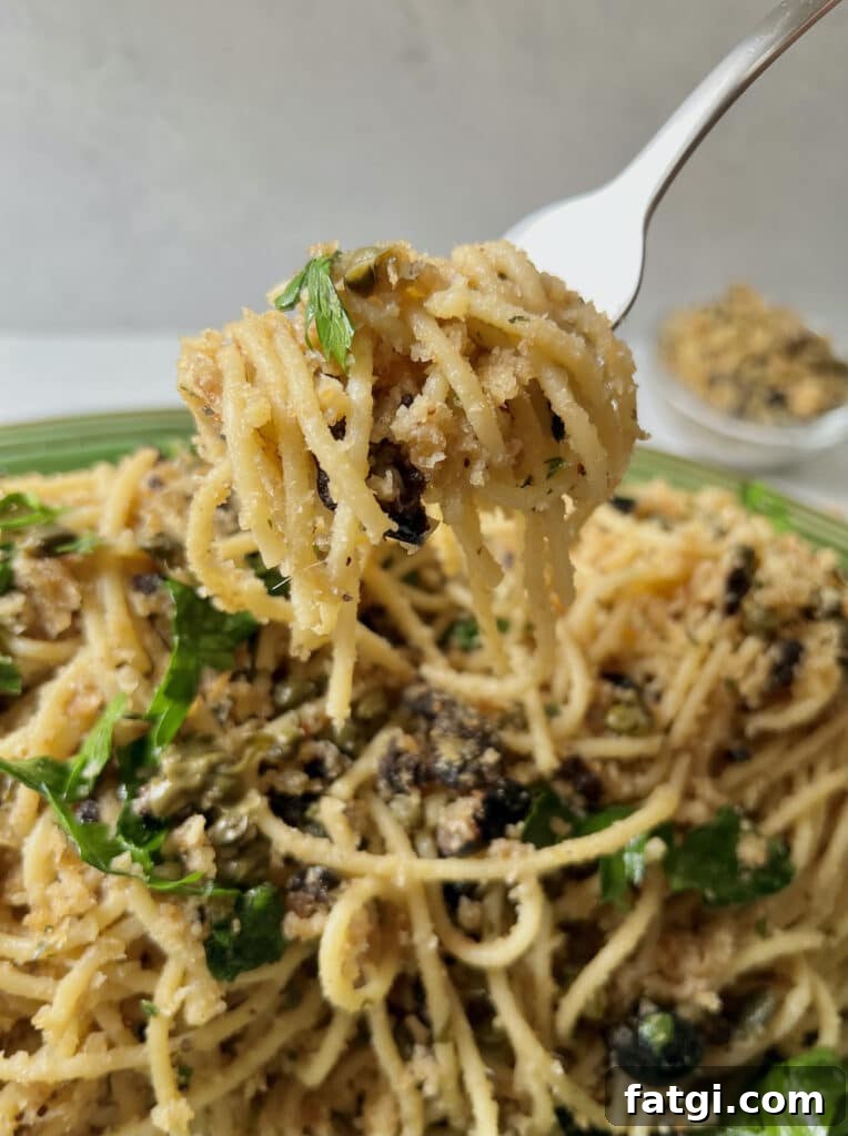 Close up of spaghetti with mollica on fork.