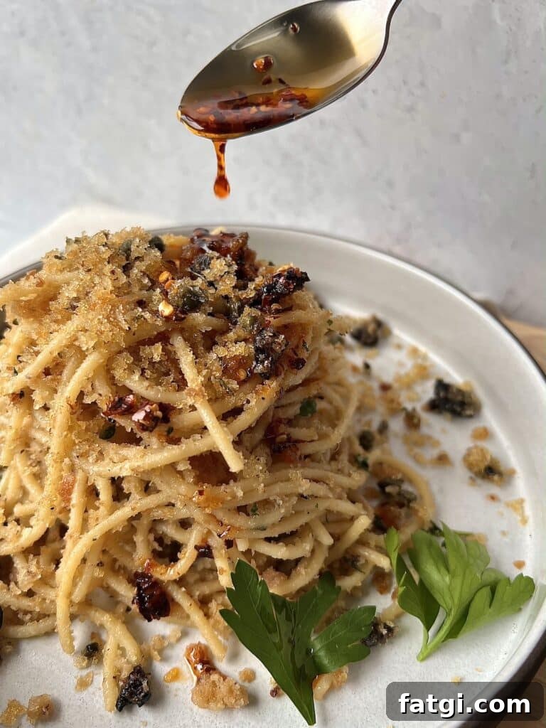 Drizzling spicy pepper oil over spaghetti ca muddica aka st joseph's spaghetti with breadcrumbs and anchovies.