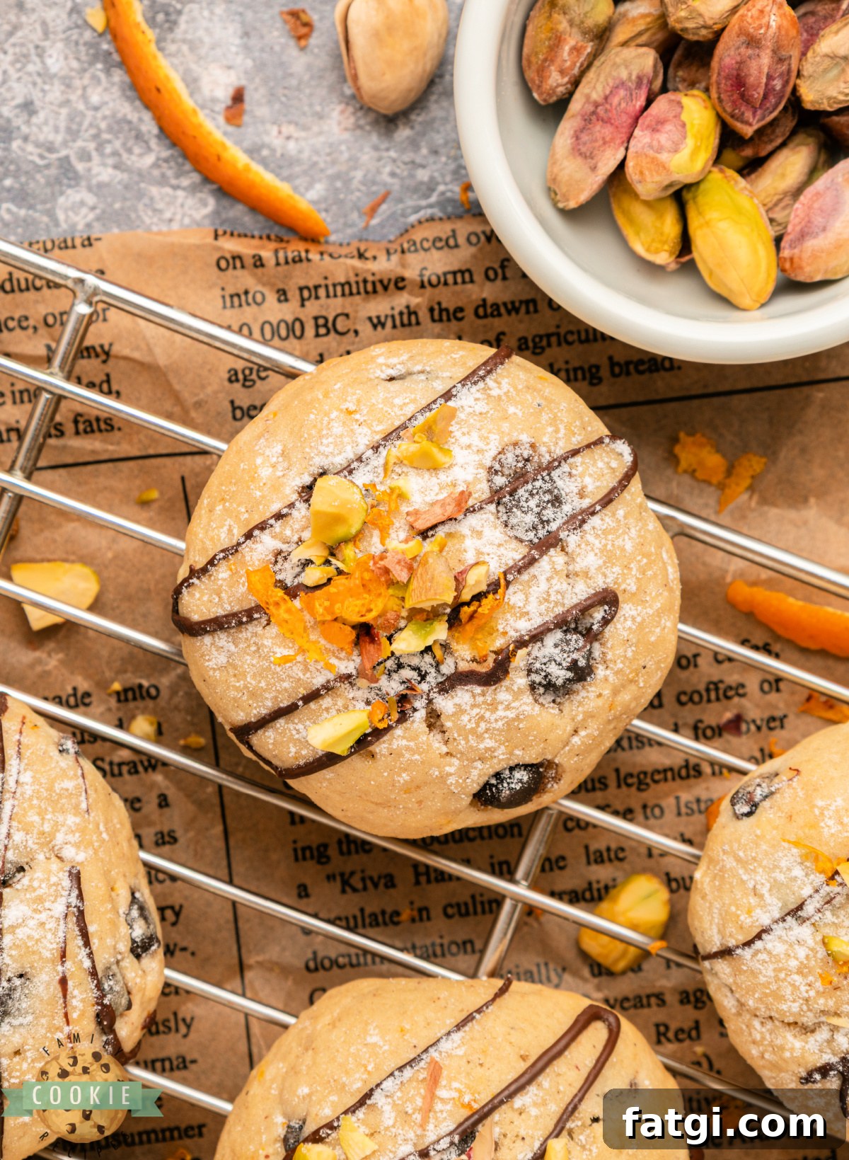 Overhead view of cannoli cookies arranged on parchment paper with pistachios and chocolate chips.