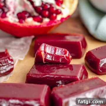 Pomegranate caramels on a platter. One has a bite removed.