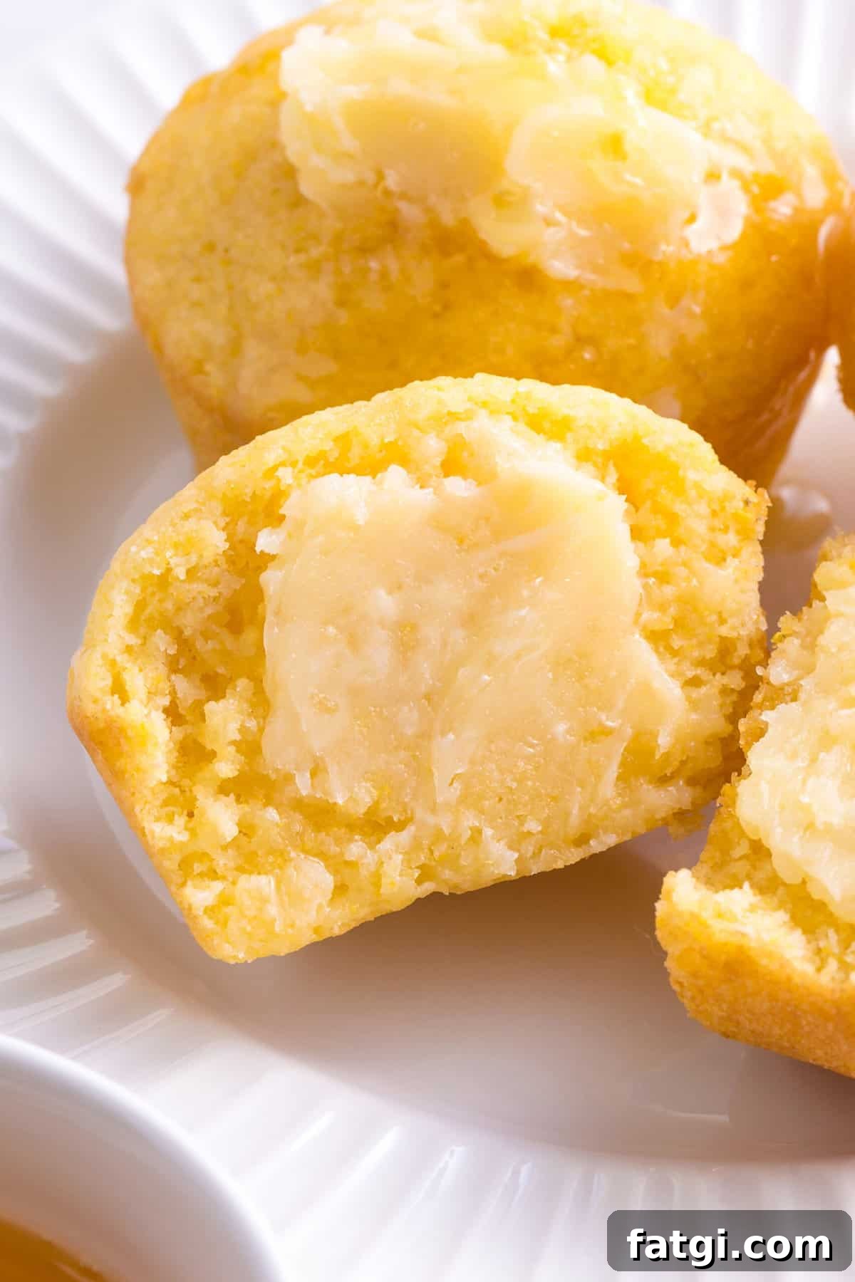 Homemade Corn Muffins with Honey Butter Recipe 9 close up image of homemade corn muffins halved and spread with homemade honey butter.