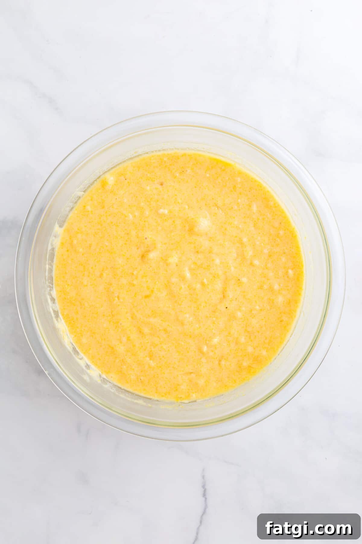 Homemade Corn Muffins with Honey Butter Recipe 5 homemade corn muffin batter in a large glass bowl.
