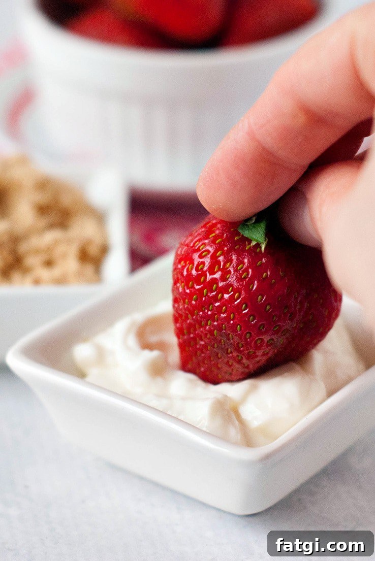 Strawberries with Sour Cream Classic Summer Dessert 3 Strawberry being dipped in sour cream