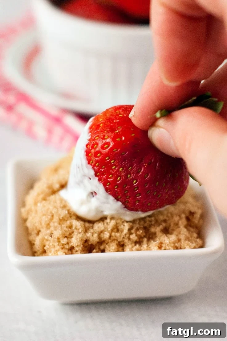 Strawberries with Sour Cream Classic Summer Dessert 4 A fresh strawberry being rolled in brown sugar after dipping in sour cream