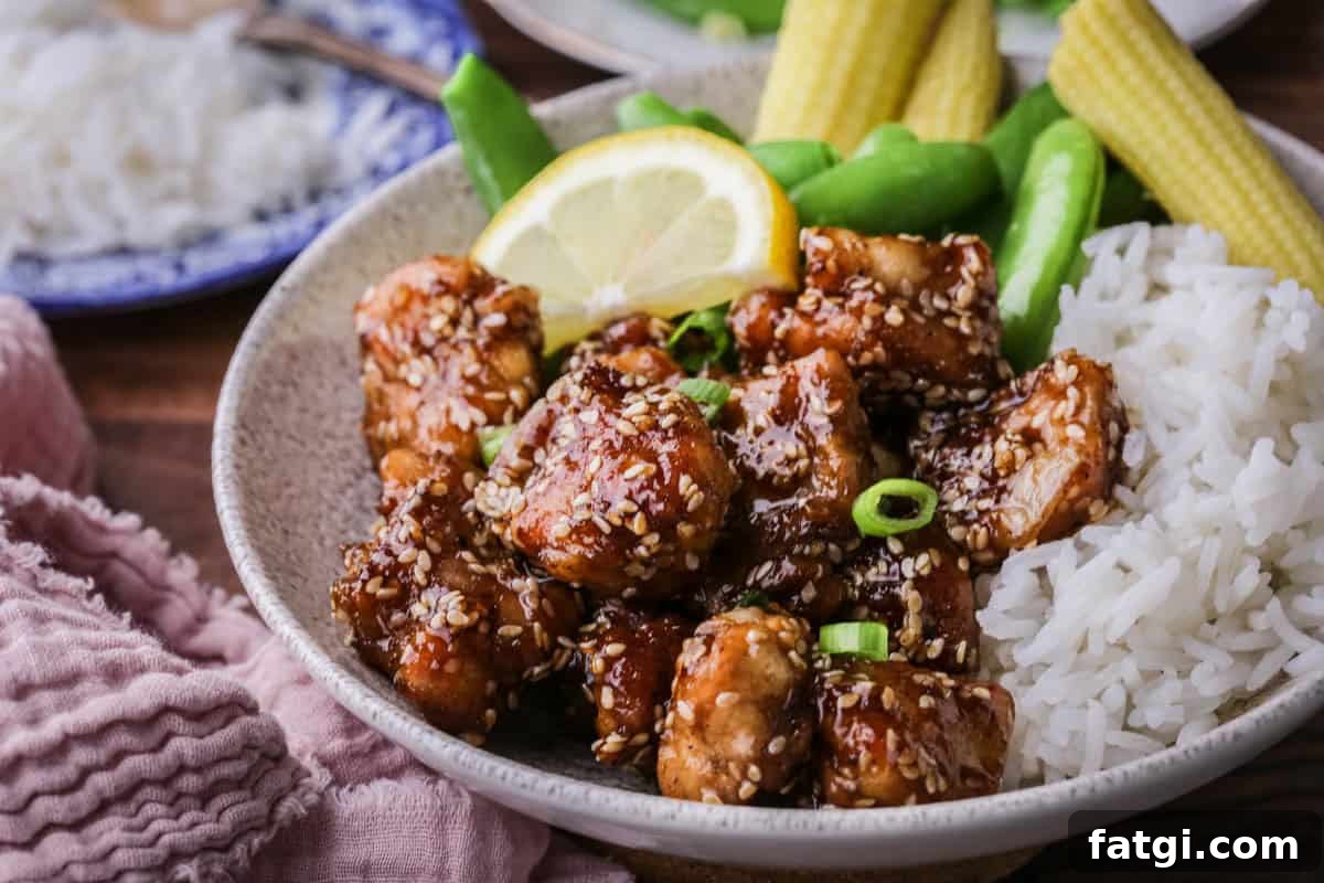 Sticky Lemon Chicken in a bowl with rice and vegetables.