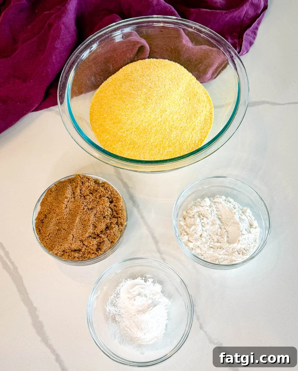 Sweet Potato Honey Cornbread Recipe 3 Dry ingredients for sweet potato honey cornbread muffins including yellow cornmeal, brown sugar, flour, and baking powder measured in glass bowls.