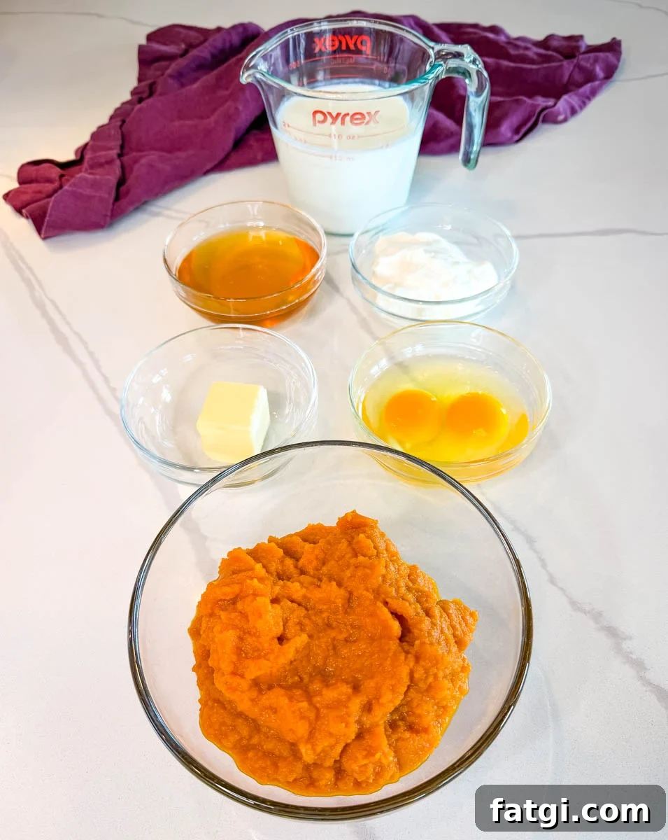 Sweet Potato Honey Cornbread Recipe 4 Ingredients for sweet potato honey cornbread muffins including sweet potato puree, milk, honey, sour cream, butter, and eggs arranged on a countertop.