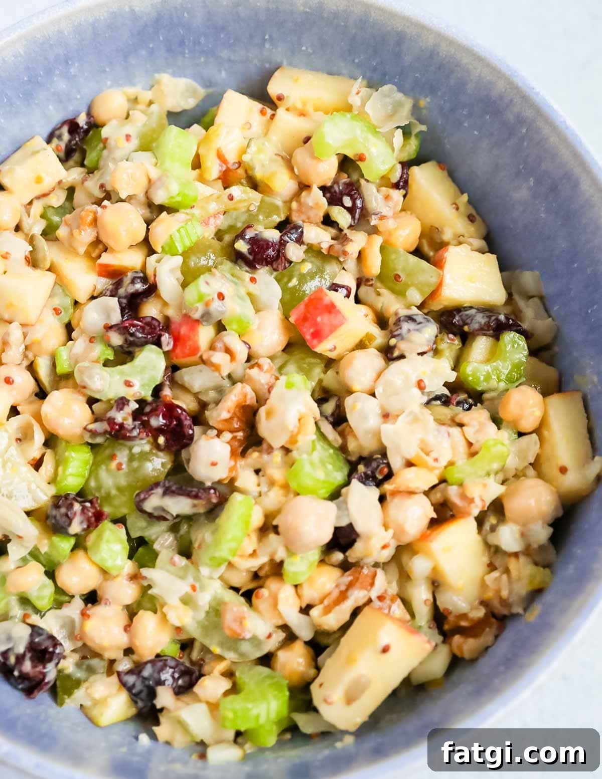 A close up of chickpea salad in a blue bowl.