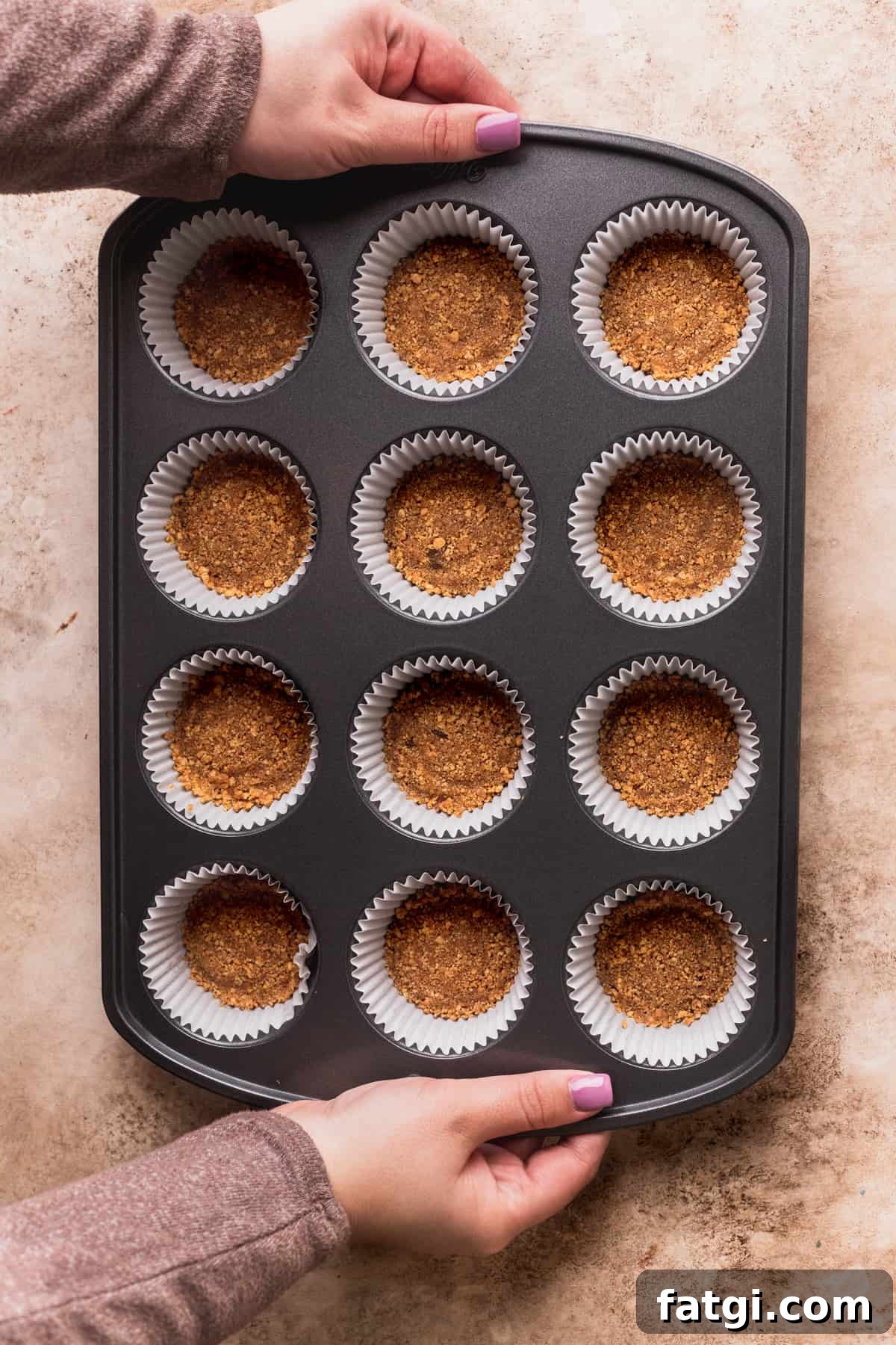 Graham cracker crust in a muffin pan.