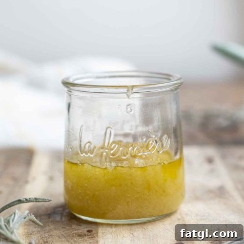 jar of homemade scalp scrub on a wood cutting board surrounded by lavender and a measuring spoon