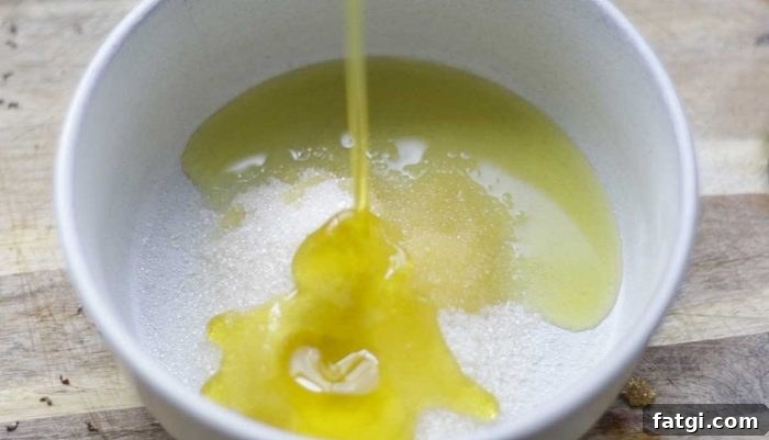 adding oil to sugar in a cream colored board