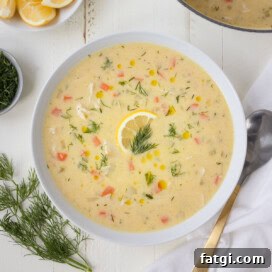 A bowl of Greek avgolemono chicken soup with fresh dill in a white bowl.