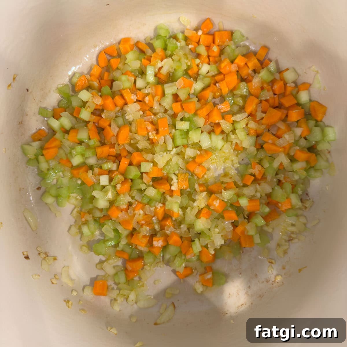 Onion, carrots, celery , and garlic cooking in a large pot.