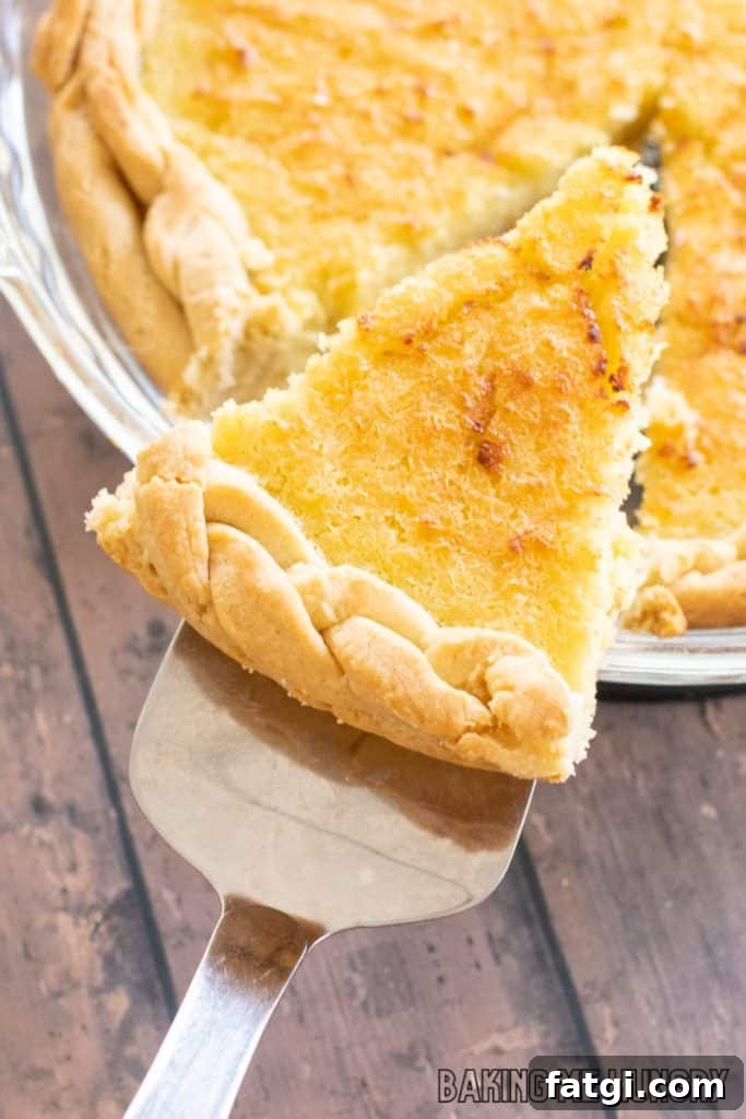 pie serving holding up a slice of sweet corn pie