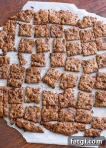Squares of chocolate chip crisps on a sheet of parchment paper.
