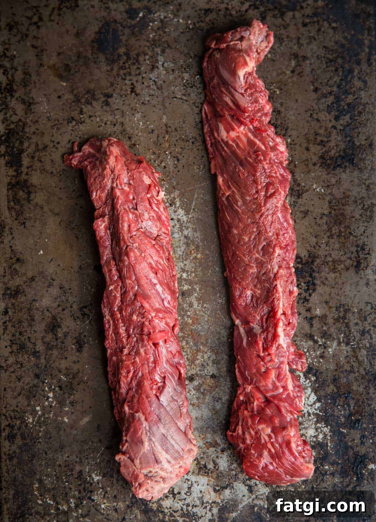 Two raw hanger steaks on a platter