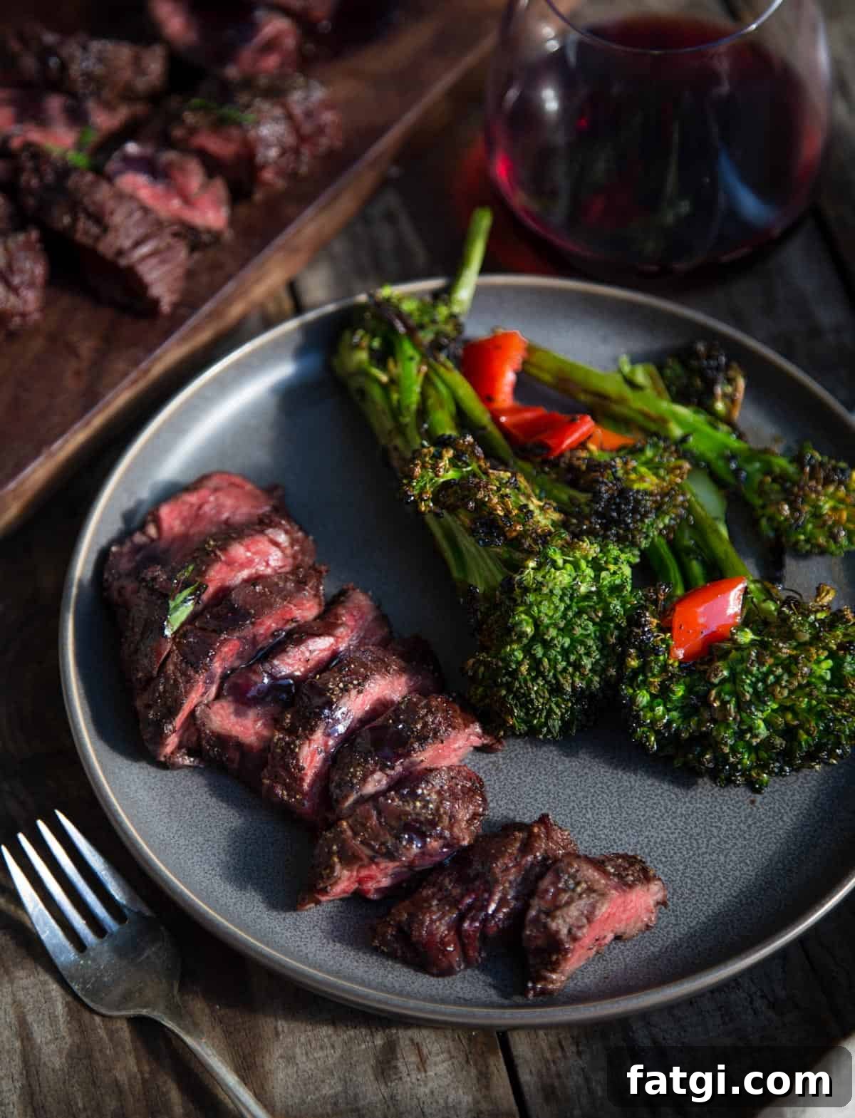 A plate with grilled beef and a side of broccolini