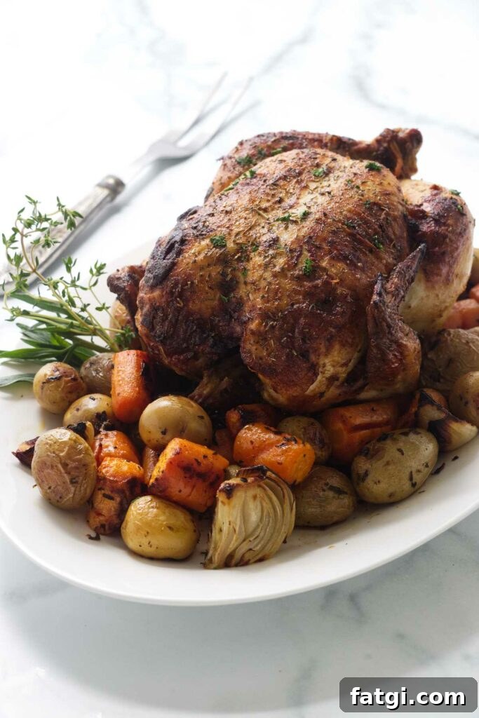 Herb Roasted Bundt Pan Chicken and Vegetables 3 Platter with the roasted chicken and vegetables. A serving fork to the left.