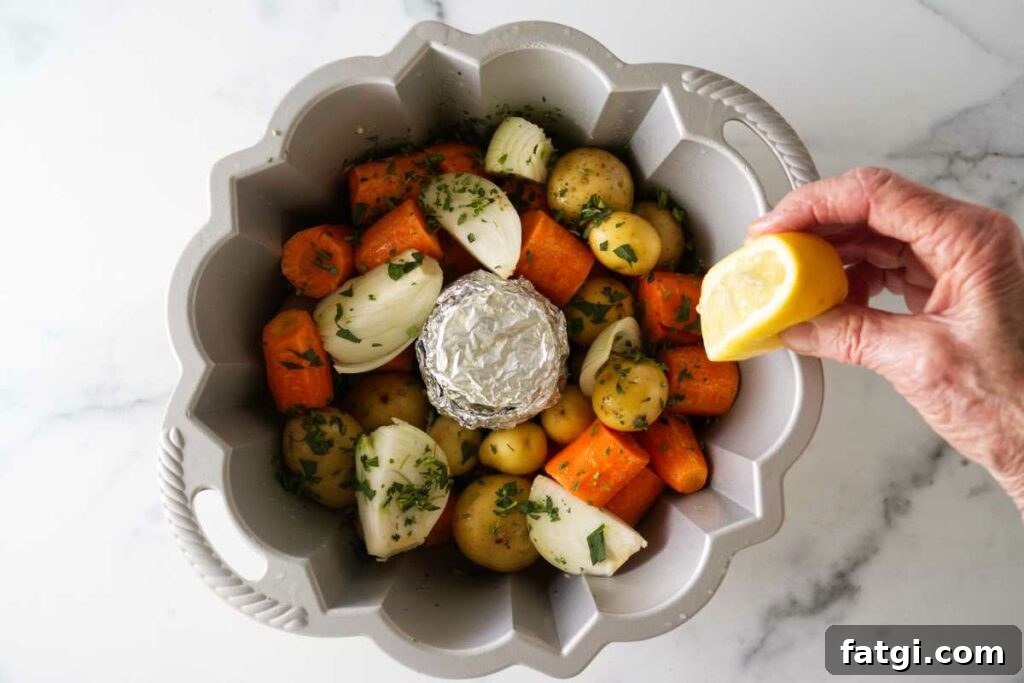 Herb Roasted Bundt Pan Chicken and Vegetables 5 A bundt pan with seasoned vegetables, squeezing a lemon on the vegetables.