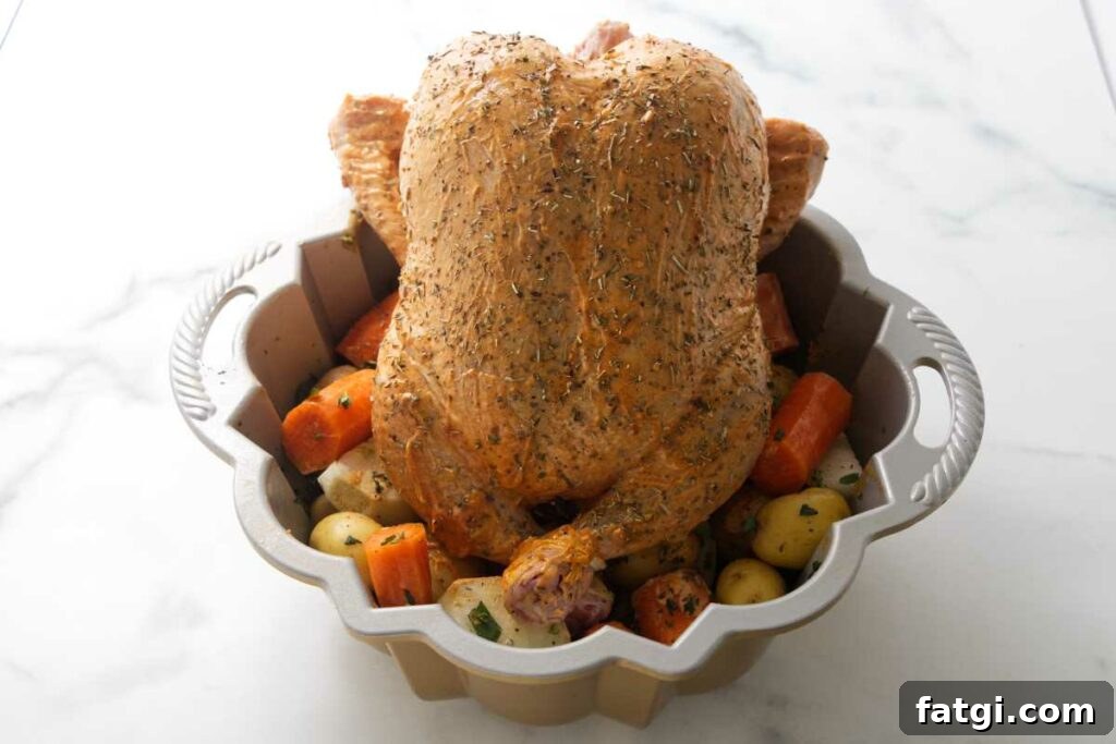 Herb Roasted Bundt Pan Chicken and Vegetables 8 A chicken propped on top of veggies in a pan.