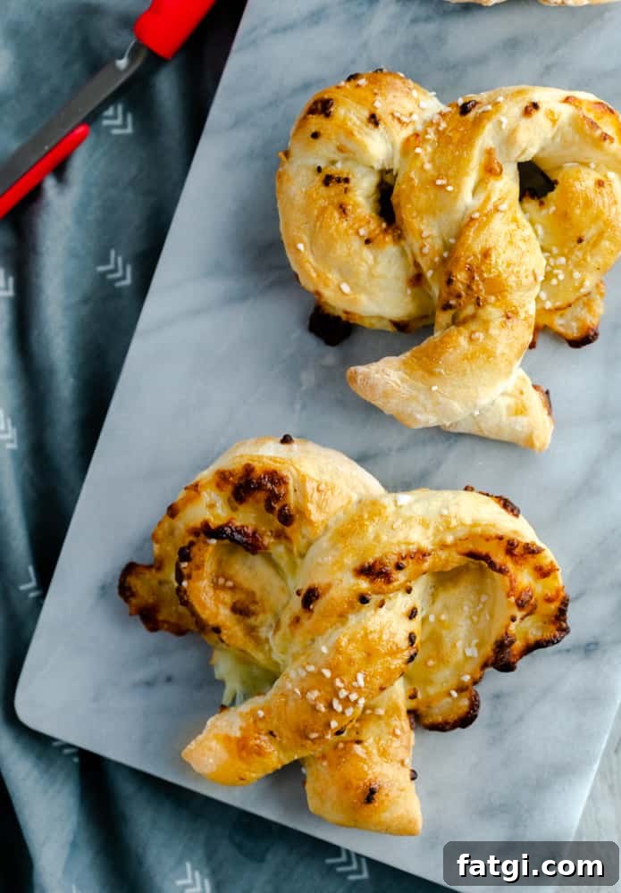 Air fryer mozzarella pretzels on marble serving board with pretzel salt.