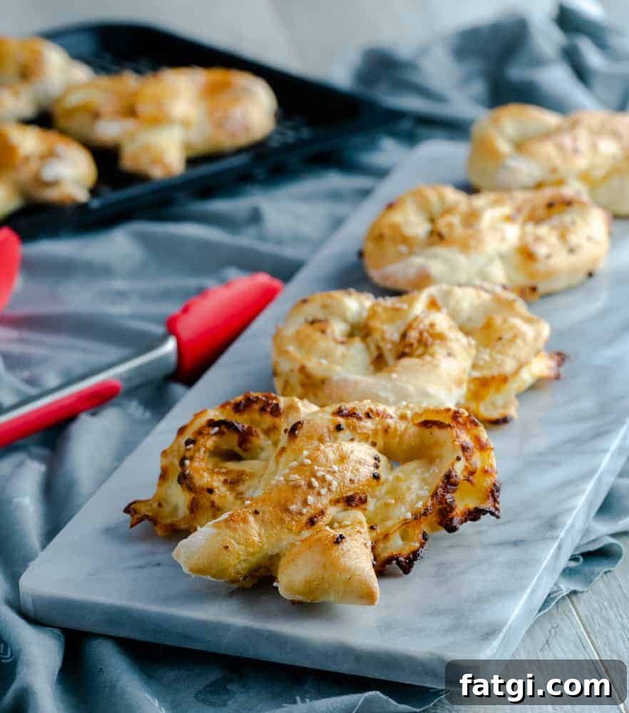 Soft and homemade pretzels rolled with mozzarella cheese and brushed with a garlic butter mixture resting on marble stone.
