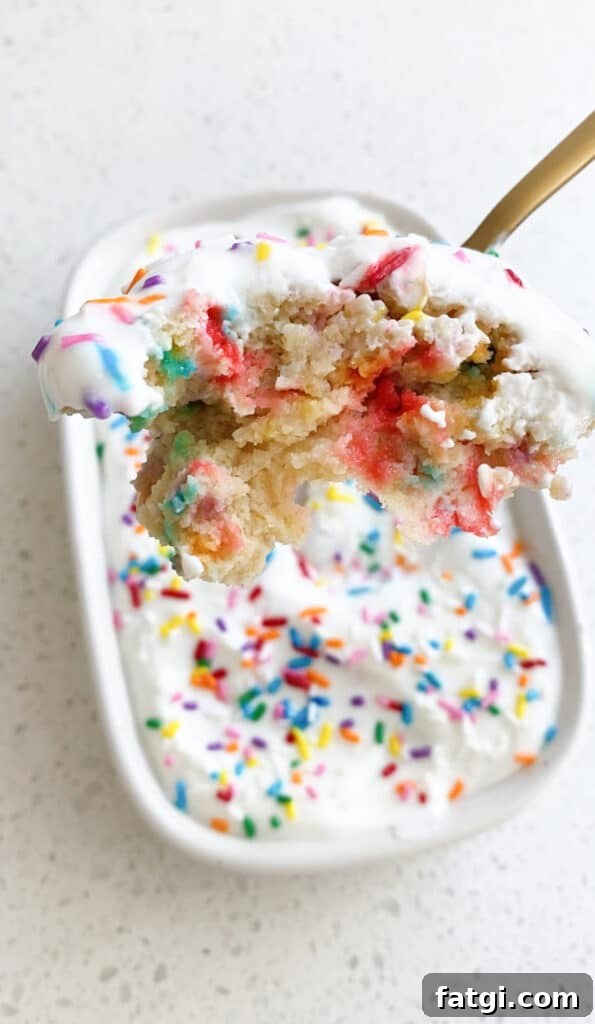 spoonful of healthy birthday cake baked oats showing fluffy texture and sprinkles