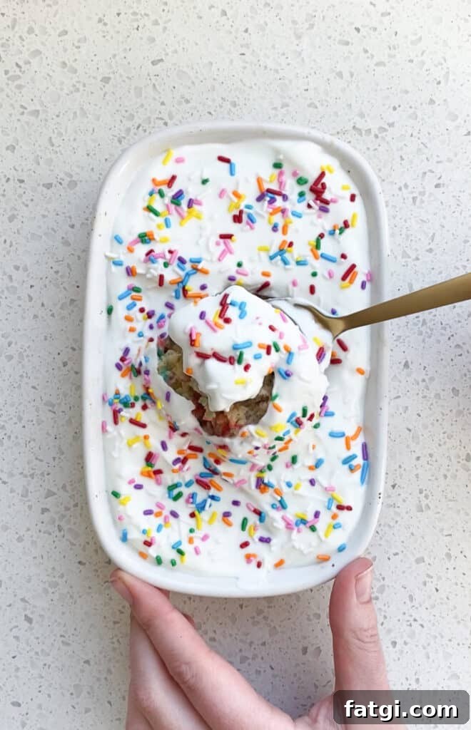 top down view of birthday cake baked oats with spoon and rainbow sprinkles