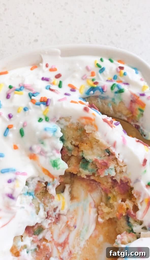 close up of high protein birthday cake baked oats with white greek yogurt icing and sprinkles