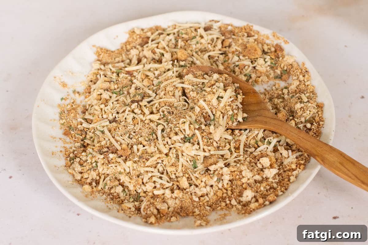 Italian breadcrumbs being scooped with a wooden spoon.