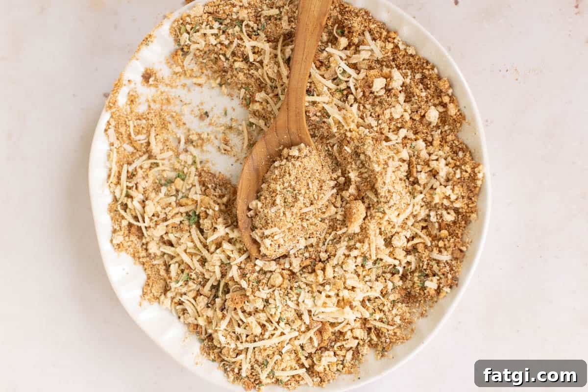 Italian breadcrumbs on a plate with a wooden spoon.