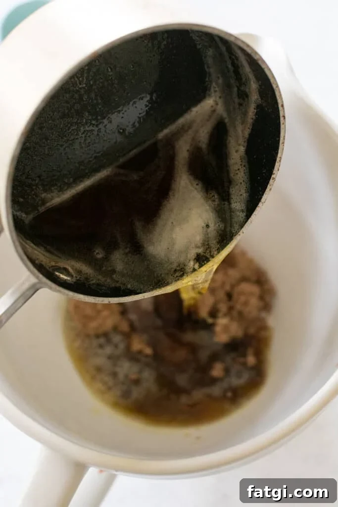 Brown butter going into a mixer with sugar.
