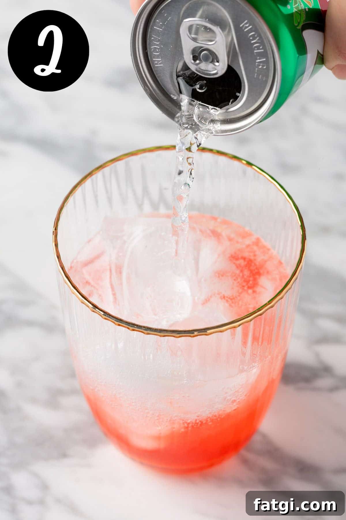 Pouring the lemon-lime soda into the cocktail glass.