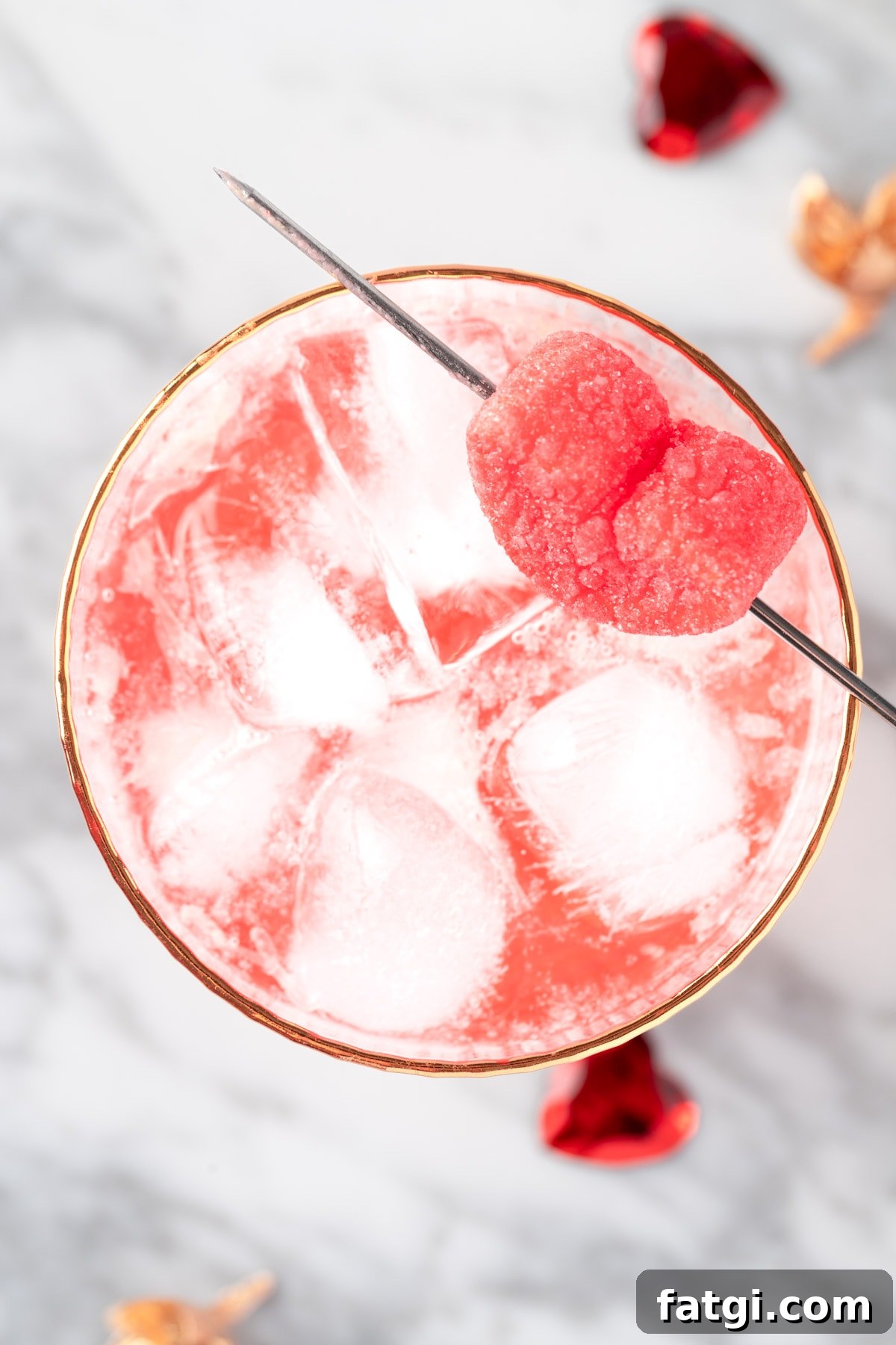 A pink Valentine’s Mocktail on a white marble table.