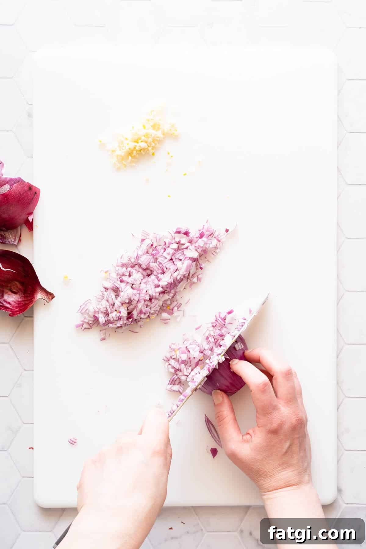 red onion being finely chopped on cutting board.