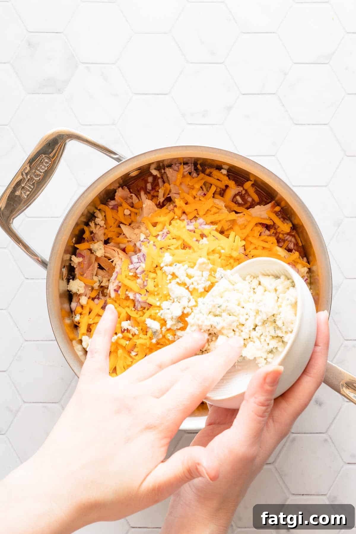 cheese being added to saucepan.